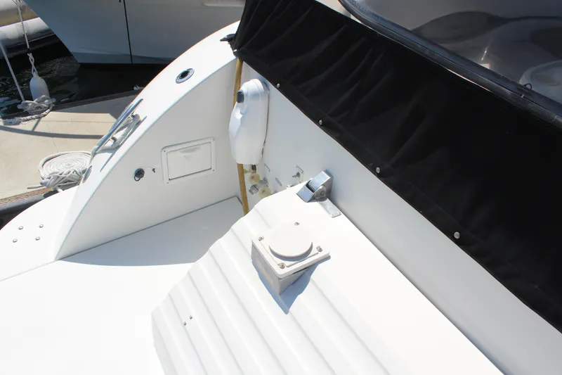 1996 Trojan 440 Express yacht deck with black canopy and dockside view.