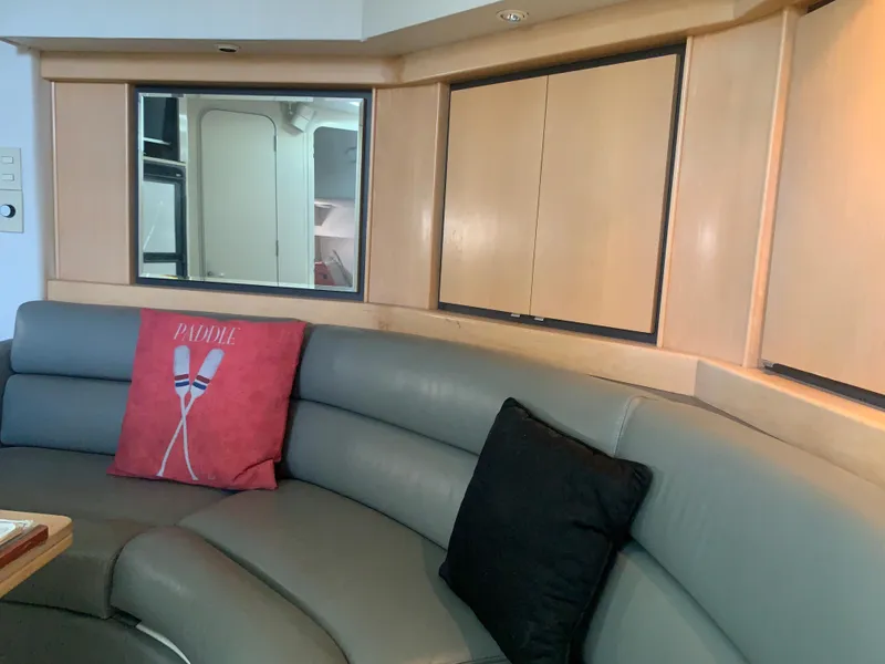 Interior of a 1996 Trojan 440 Express yacht with curved seating and decorative pillows.