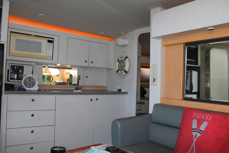 Interior of a 1996 Trojan 440 Express yacht with modern kitchen and cozy seating area.