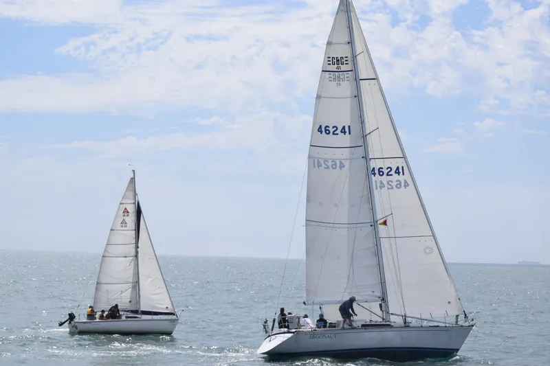 Two sailboats, including a 1985 C&C 41, sailing on open sea.