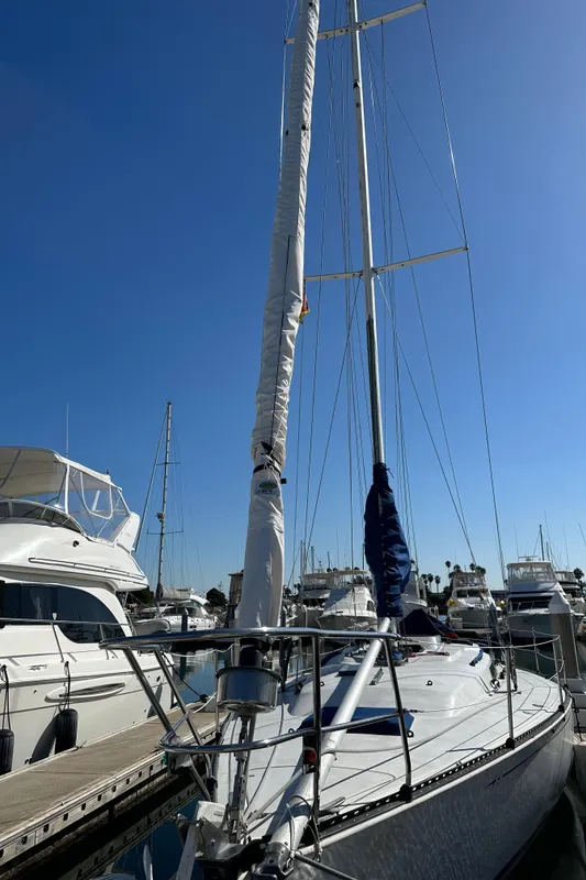 1985 C&C 41 sailboat docked in marina under clear sky.