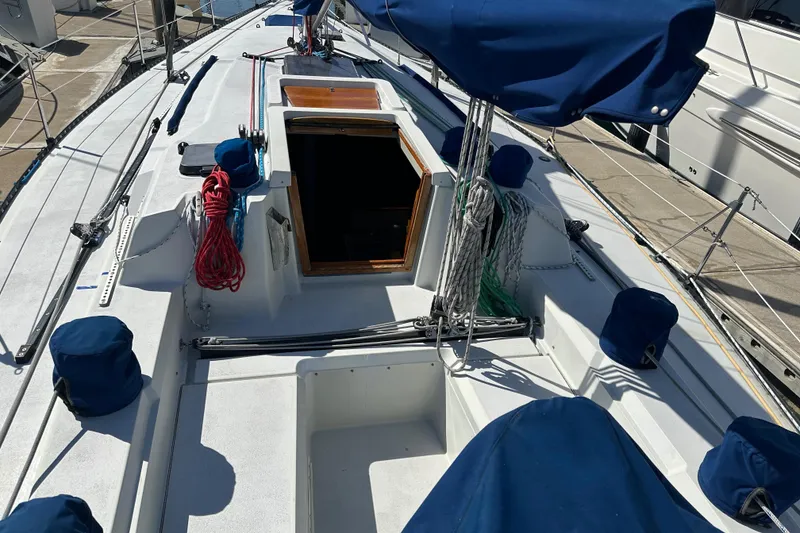 1985 C&C 41 sailboat with blue covers docked at marina.