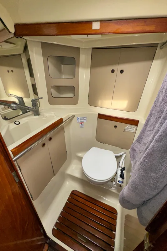 1985 C&C 41 yacht bathroom with toilet and storage cabinets.