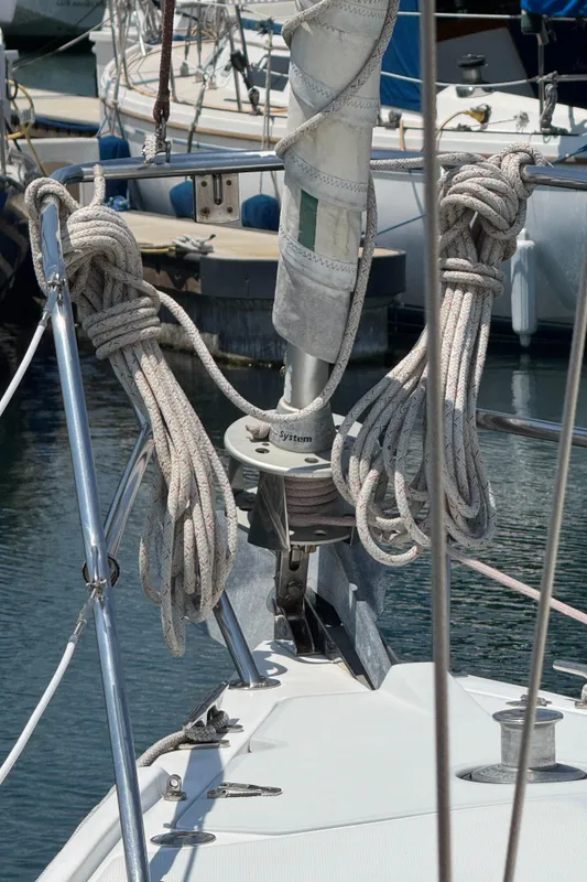 Bow of 1998 Catalina 36 MkII sailboat with coiled ropes and docked boats in background.