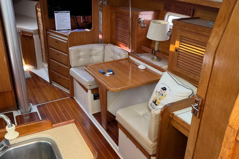 Interior of 1998 Catalina 36 MkII sailboat with wooden furnishings and cozy seating area.