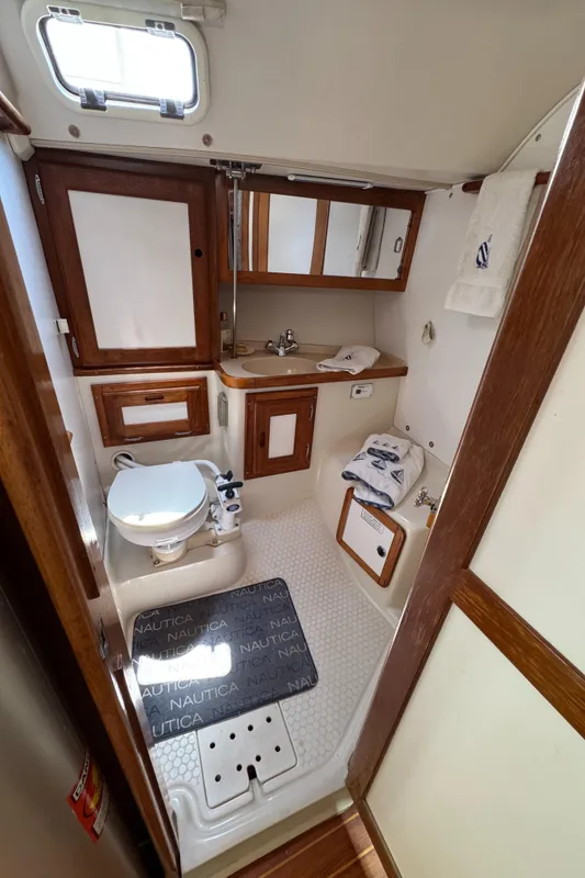 1998 Catalina 36 MkII yacht bathroom with wooden cabinets and nautical-themed decor.