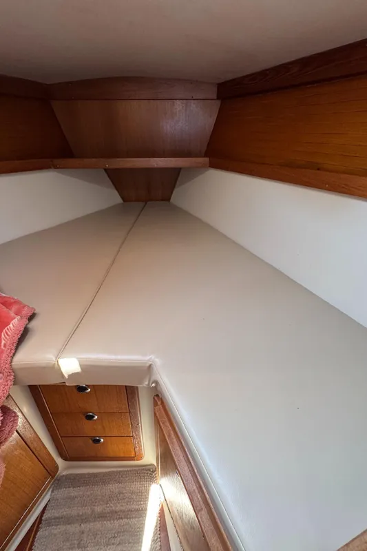 Interior cabin of 1998 Catalina 36 MkII sailboat with cushioned berth and wooden cabinetry.