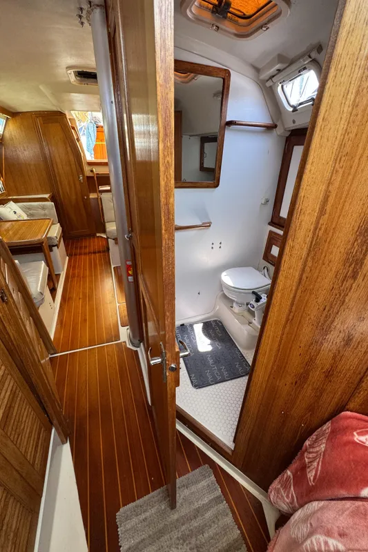 Interior of 1998 Catalina 36 MkII sailboat with wooden flooring and compact bathroom.