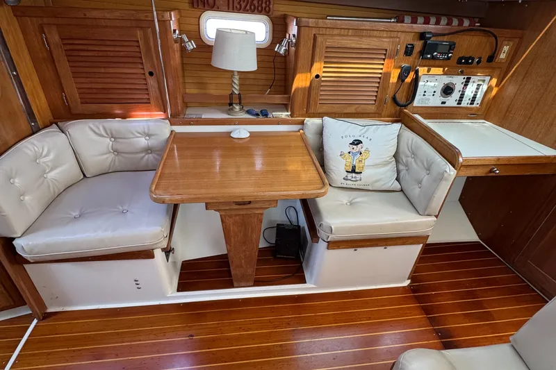 Interior of 1998 Catalina 36 MkII sailboat with wooden table and cushioned seating.