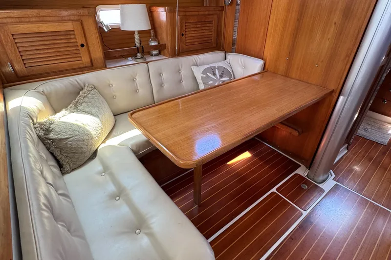 Interior of a 1998 Catalina 36 MkII sailboat with wooden table and cushioned seating.