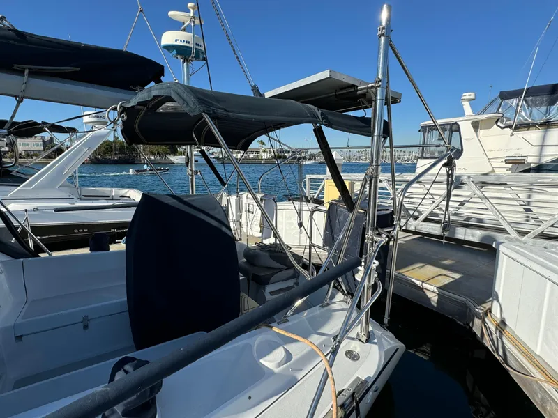 1992 Hunter 35 sailboat docked at marina, featuring blue canopy and clear sky.