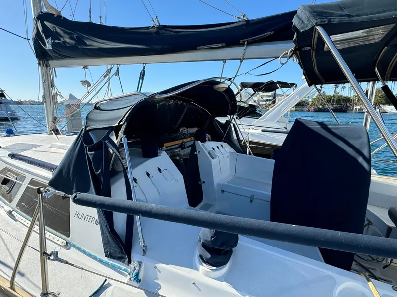 Sailboat Hunter 35, 1992 model, docked with blue canopy and clear sky background.