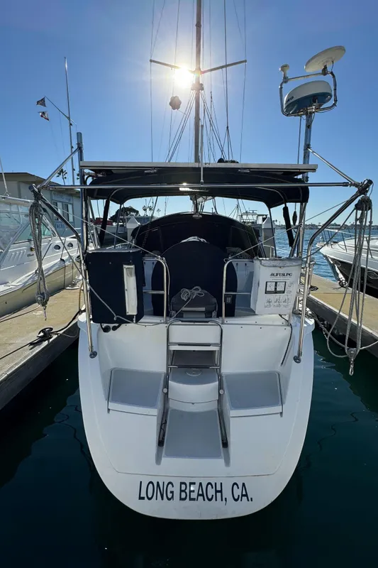 1992 Hunter 35 sailboat docked in Long Beach, CA, with sunlit mast and marina backdrop.