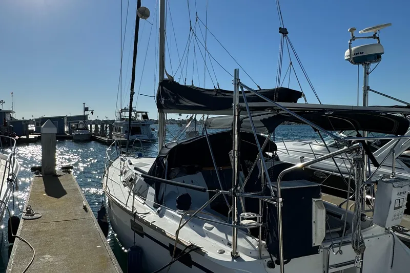 Sailboat docked at marina, 1992 Hunter 35 model, sunny day, calm waters.