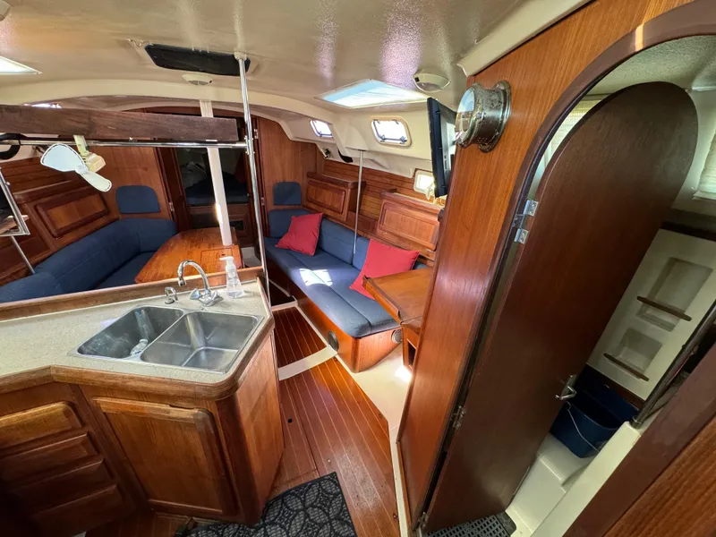 Interior of 1992 Hunter 35 sailboat with wood finish, kitchen, and seating area.