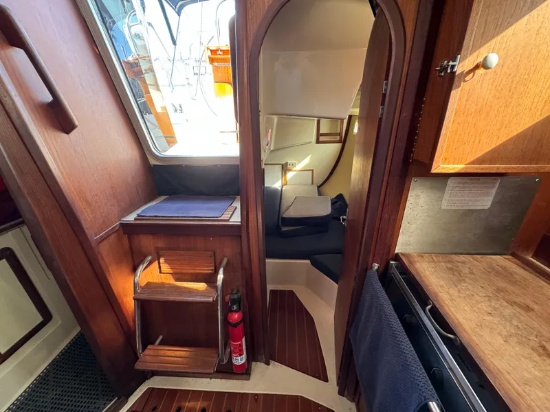 Interior of a 1992 Hunter 35 sailboat, featuring wooden cabinetry and compact living space.