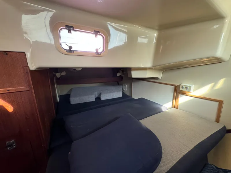 Cozy cabin interior of a 1992 Hunter 35 sailboat with bedding and a porthole.