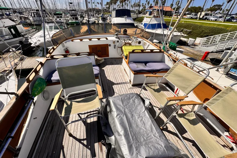 1980 Hershine Trawler deck with chairs and cushions in a marina setting.