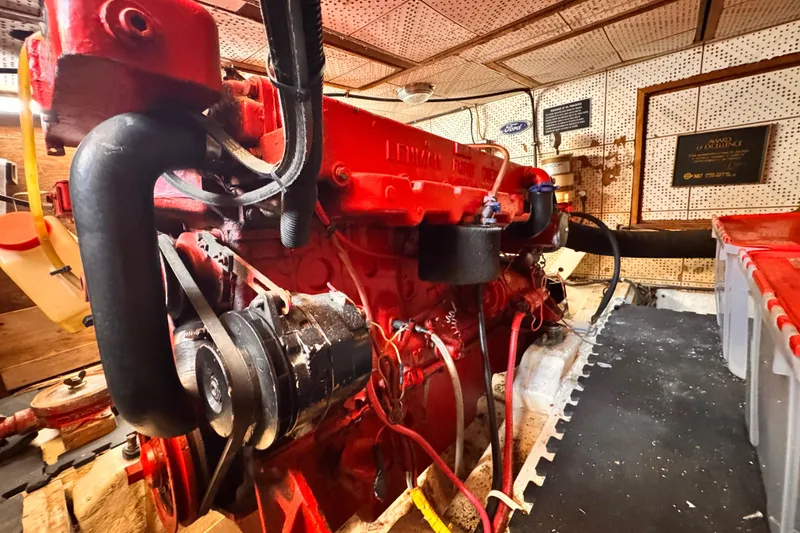 Red engine inside a 1980 Hershine Trawler boat, detailed view of mechanical components.
