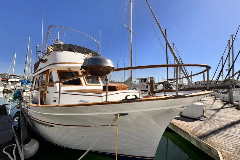 1980 Hershine Trawler docked at marina under clear blue sky.