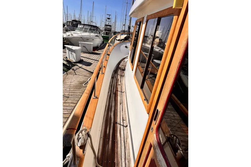 1980 Hershine Trawler docked, showcasing wooden deck and cabin details.