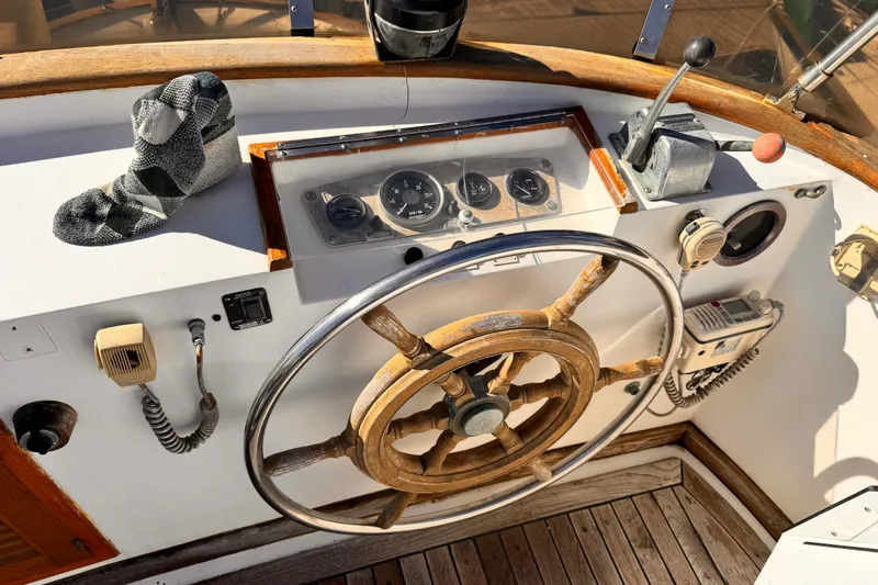 1980 Hershine Trawler helm with wooden wheel, gauges, and nautical controls.