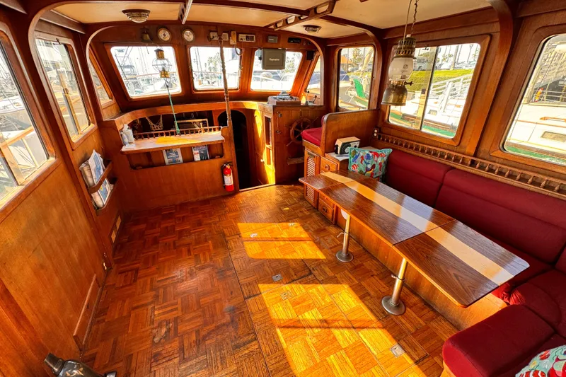 Interior of a 1980 Hershine Trawler with wooden decor and red seating.