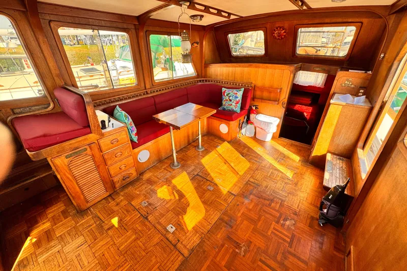 Interior of a 1980 Hershine Trawler with wood paneling and red seating.