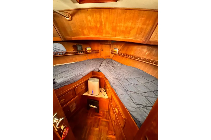 Cozy cabin interior of 1980 Hershine Trawler with wooden finish and twin beds.