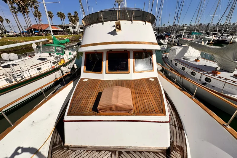 1980 Hershine Trawler docked at marina, surrounded by sailboats under clear blue sky.