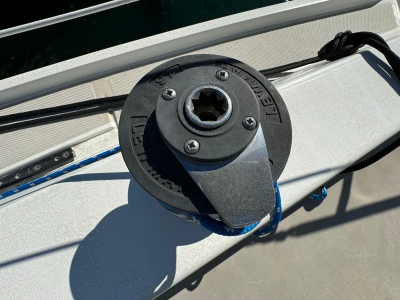 Winch on 1987 Catalina 34 sailboat deck, with blue rope and sunlight.