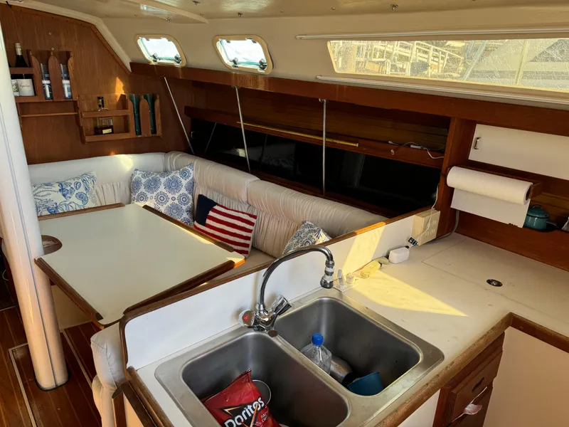Interior of 1987 Catalina 34 sailboat with cozy seating and kitchen area.