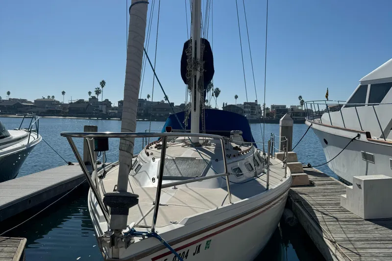 1987 Catalina 34 sailboat docked at marina under clear blue sky.