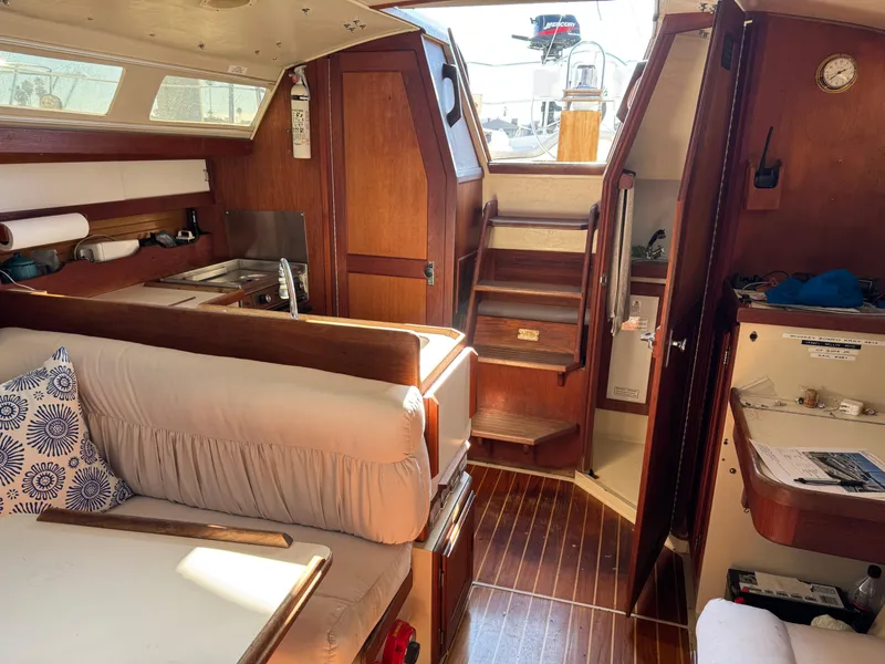 Interior of 1987 Catalina 34 sailboat with wood finish and cozy seating area.