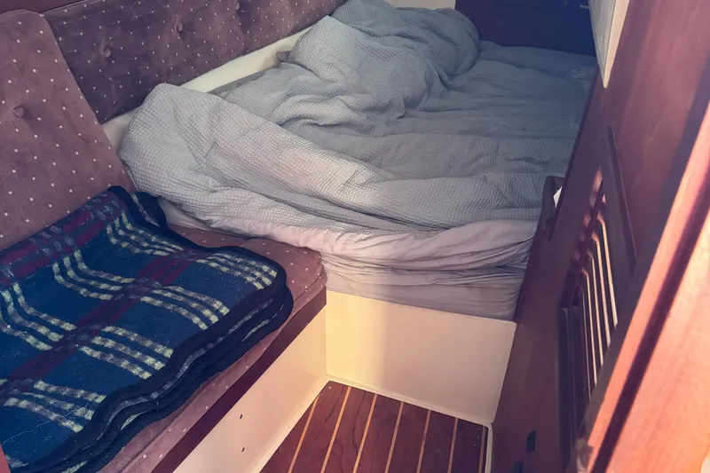 Cozy cabin interior of 1987 Catalina 34 sailboat with bed and seating area.