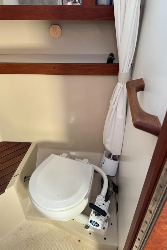 1987 Catalina 34 boat bathroom with compact marine toilet and wooden accents.