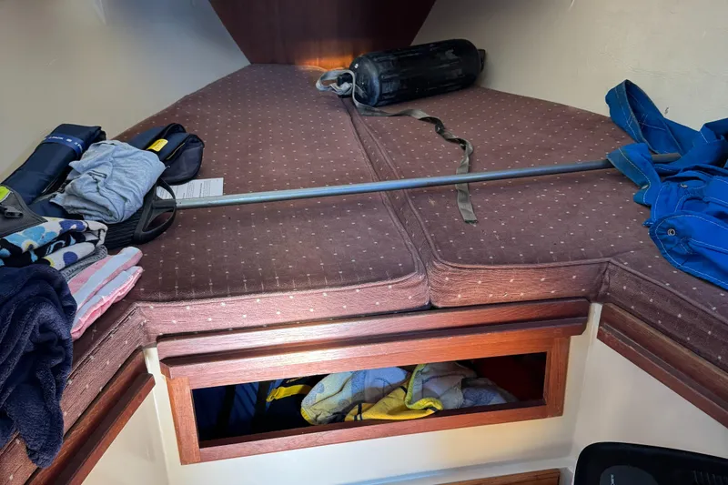 Interior cabin of a 1987 Catalina 34 sailboat with storage and bedding.