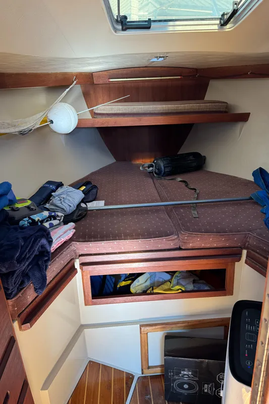 Interior cabin of a 1987 Catalina 34 sailboat with storage and bedding.