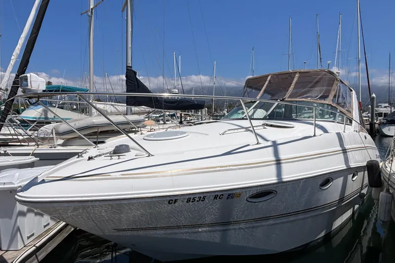 2004 Larson 310 boat docked at marina with clear blue sky background.