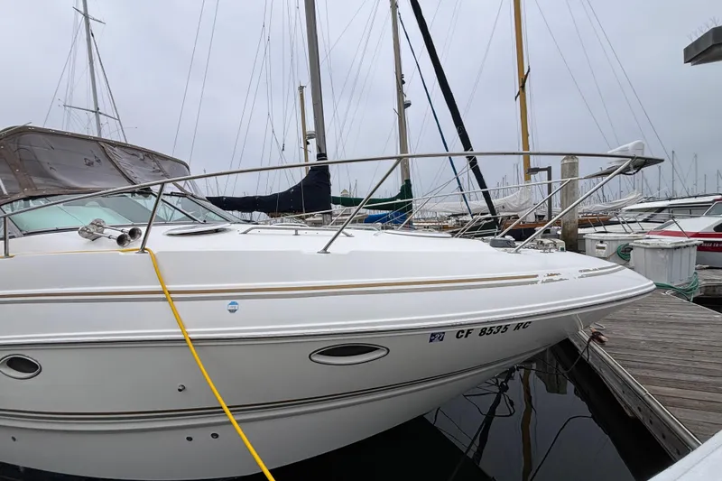 2004 Larson 310 boat docked at marina, surrounded by other sailboats.