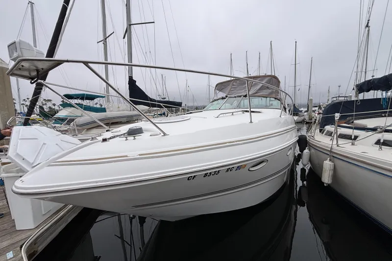 2004 Larson 310 boat docked at marina, surrounded by other sailboats.