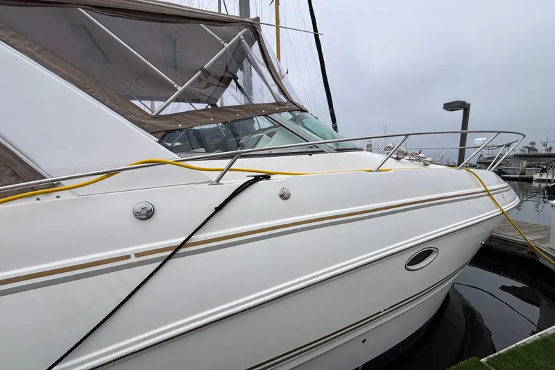 2004 Larson 310 boat docked at marina, featuring sleek white exterior and chrome railings.