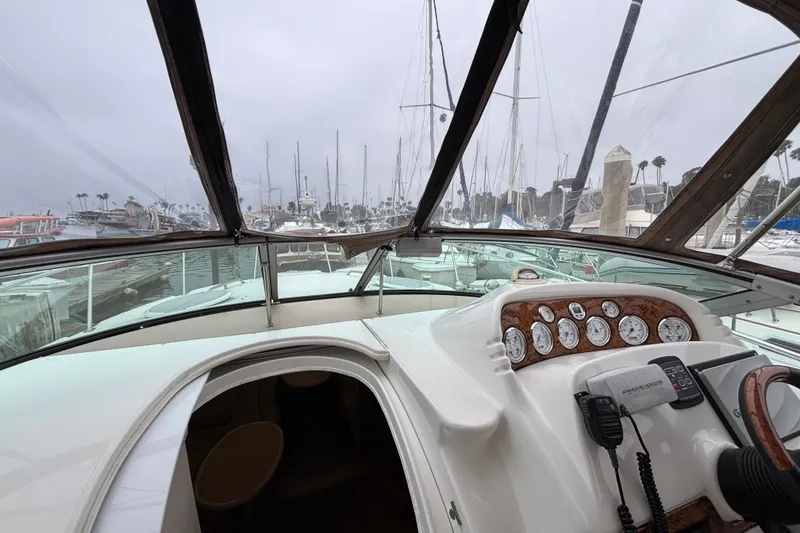 Interior view of a 2004 Larson 310 boat cockpit with marina background.