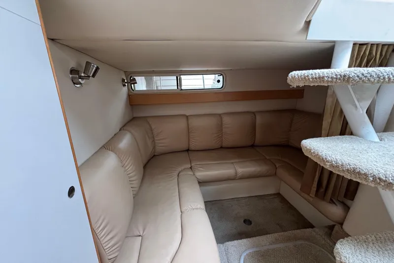 Interior of a 2004 Larson 310 boat with beige leather seating and carpeted stairs.