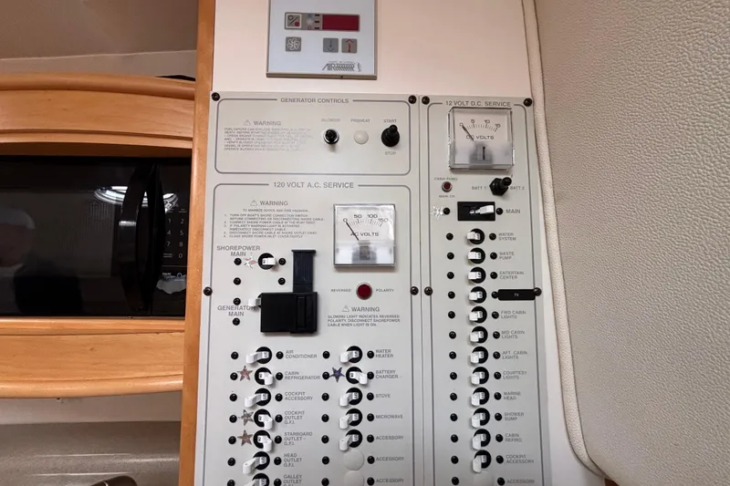 Electrical control panel in a 2004 Larson 310 boat, featuring AC and DC service switches.