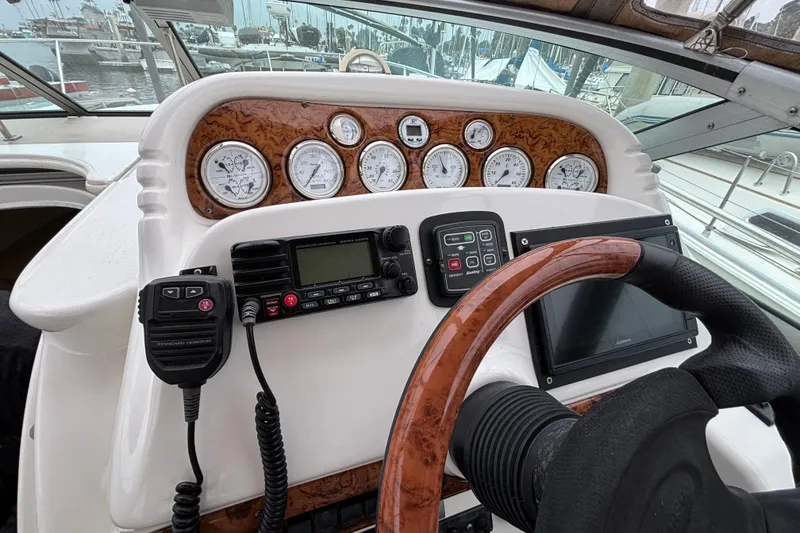 Helm of 2004 Larson 310 boat with gauges, radio, and steering wheel.