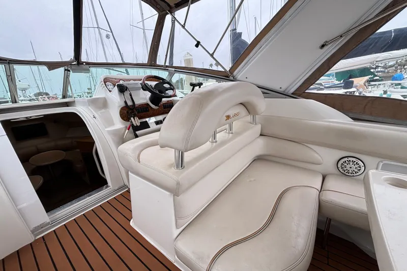 2004 Larson 310 boat interior with white seating and wooden flooring.