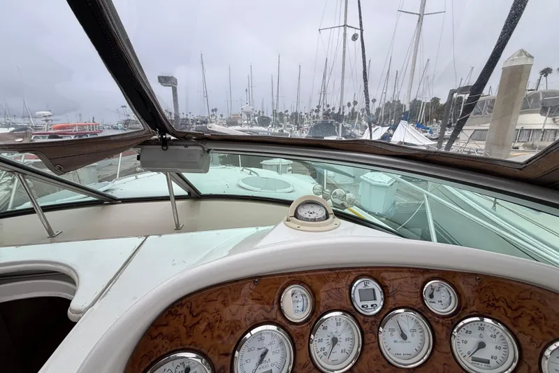 Interior view of a 2004 Larson 310 boat dashboard with marina background.