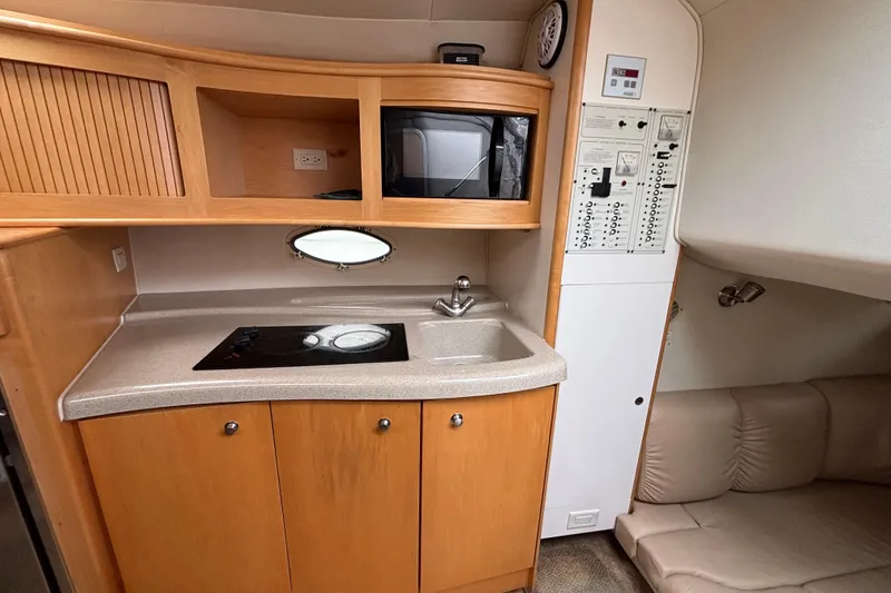 2004 Larson 310 boat interior with kitchenette, microwave, and control panel.