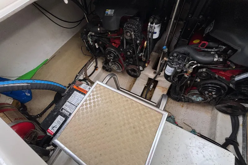 Engine compartment of a 2004 Larson 310 boat, showing dual engines and battery.